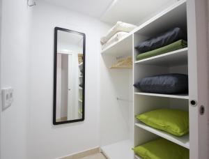 een kamer met een spiegel en planken met kussens bij R&E apartments in Torremolinos
