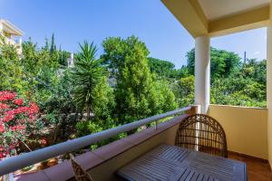a balcony with a bench and trees and bushes at Aurora Sol in Luz