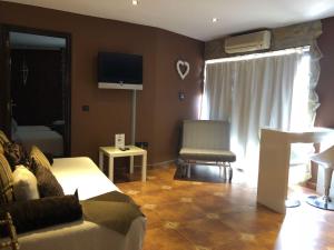 a living room with a couch and a tv at Apartamentos Los Angeles in Alcañiz