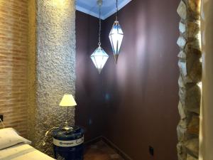 1 dormitorio con 2 luces colgando de una pared en Apartamentos Los Angeles, en Alcañiz