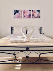 two white swansrendered to look like they are kissing on a bed at Vila Kosteli in Himare