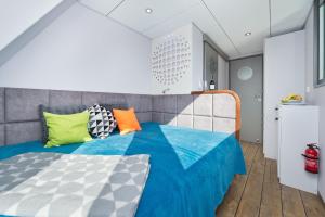 a bedroom with a bed with colorful pillows on it at Houseboat in Błotnik