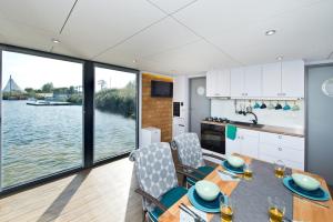 a kitchen and dining room with a view of the water at Houseboat in Błotnik