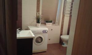 a bathroom with a washing machine and a sink at Апартаменты-студио in Izmail