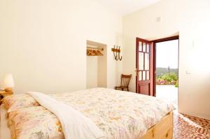 a white bedroom with a bed and a window at B&B Candelária in Loulé