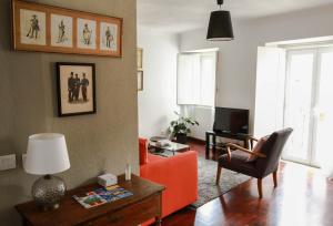リスボンにあるCozy and Spacious apartment in Graça, Lisbonのリビングルーム(オレンジ色のソファ、椅子付)