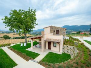 a small house on a hill with a tree at Serre Alte Landscape Luxury Rooms in Matelica