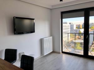 Zimmer mit einem Tisch und einem TV an der Wand in der Unterkunft Living Point Residence in Warschau