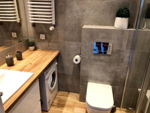 ein Badezimmer mit einem WC, einem Waschbecken und einer Waschmaschine in der Unterkunft Living Point Residence in Warschau