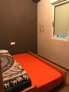 プエルト・デ・サグントにあるMarisolの小さなベッドルーム(オレンジ色の毛布付きのベッド付)