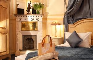 a bedroom with a bed with a shopping bag on it at Hotel Residence Henri IV in Paris