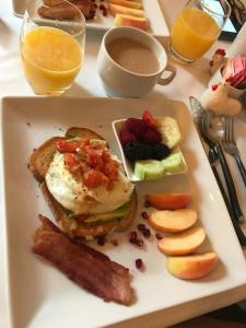 a plate of breakfast food with eggs and bacon and fruit at Inn on the Riverwalk in San Antonio