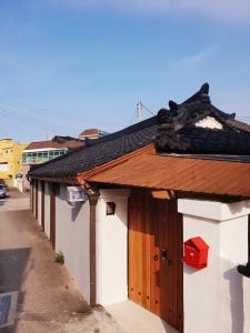 a building with a wooden door and a roof at Dal Garam Guesthouse in Gangneung