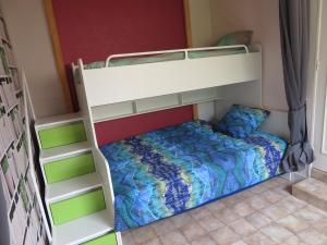 アンボワーズにあるGîte La Pierre Qui Tourneの二段ベッド(青と緑の掛け布団付)