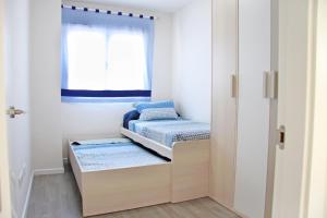 Habitación pequeña con 2 camas y ventana en Ciencias Forum Apartment by A3Rentals, en Granada