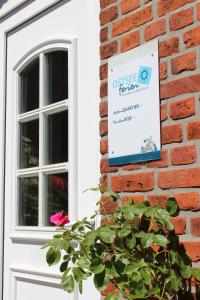 a sign on the side of a brick building with a flower at OSTSEEferien am BARFUSSpark in Hasselberg