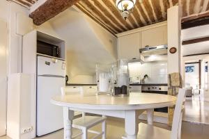eine Küche mit einem weißen Tisch und einem weißen Kühlschrank in der Unterkunft Bijou Apartment in Safranier - Old Town Antibes in Antibes