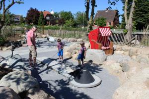 a man and two children standing next to a hat at OSTSEEferien am BARFUSSpark in Hasselberg