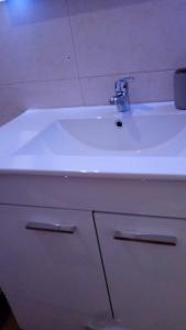 a white sink with a faucet on top of it at Casa do Carvoeiro II-GOOD AND CHEAP!!! in São Vicente