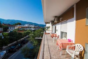 a balcony with tables and chairs on a building at Apartments Anesis Pantazis in Asprovalta