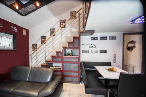 a room with a staircase and a table and chairs at bodensee-fewo Modernes & TOP-ausgestattetes Appartement incl Netflix, e-Ladestation, Fahrradgarage in Uhldingen-Mühlhofen