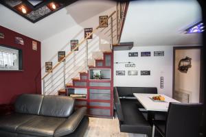 a room with a staircase and a table and chairs at bodensee-fewo Modernes & TOP-ausgestattetes Appartement - Netflix, e-Ladestation, Fahrradgarage in Uhldingen-Mühlhofen