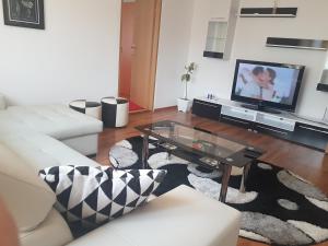 a living room with a white couch and a coffee table at Apartament Central Miguel in Turda