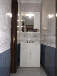 y baño con lavabo blanco y espejo. en Hotel Alemán en Gualeguaychú