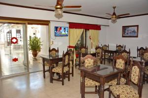 een eetkamer met tafels en stoelen en een tv bij Hotel Alemán in Gualeguaychú