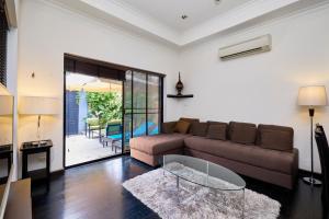 a living room with a couch and a glass table at VIEW TALAY VILLAs POOL 60, JOMTIEN BEACH, PATTAYA in Jomtien Beach