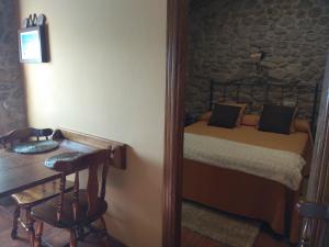 a bedroom with a bed and a table and a desk at Casa Ruso in Os Muinos