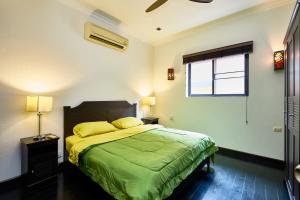 a bedroom with a bed with green sheets and a window at VIEW TALAY VILLAs POOL 60, JOMTIEN BEACH, PATTAYA in Jomtien Beach