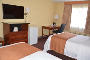a hotel room with two beds and a flat screen tv at Columbus Grand Hotel & Banquet Center in Worthington