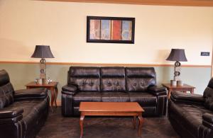 a living room with a leather couch and two tables at Columbus Grand Hotel & Banquet Center in Worthington