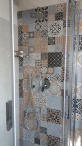 a bathroom with a shower with a tiled wall at B&b la valletta in Serravalle Scrivia
