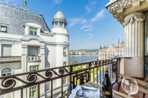 a balcony with wine glasses and a view of a building at Breathless view Parliament 2 Luxury Suites with terrace FREE PARKING RESERVATION NEEDED in Budapest