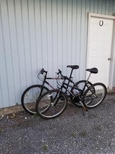 dos bicicletas están estacionadas al lado de un edificio en Runaway Bay Guest House, en Hillier