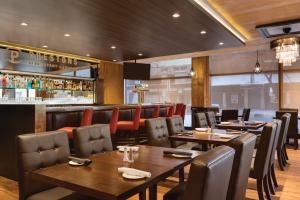 a restaurant with tables and chairs and a bar at Coast Edmonton Plaza Hotel by APA in Edmonton