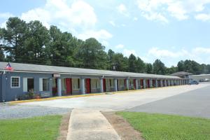 a large building with red doors and a parking lot at Roadway Inn Troy in Troy