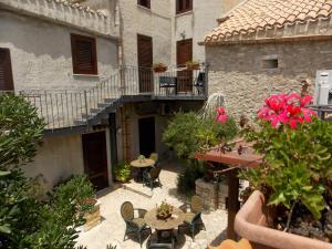 un patio al aire libre con mesas y sillas y un edificio en Camere Di Ulisse, en Erice