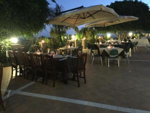 a group of tables and chairs with umbrellas at Le Quattro Sorelle in Saline Joniche