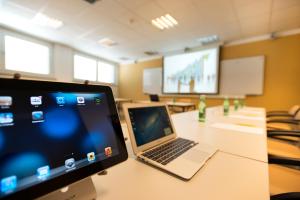 un ordinateur portable assis sur une table dans une salle de classe dans l'établissement Hotel City, à Villach