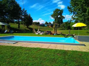 a swimming pool in a yard with an umbrella at Village Minhoure in Felgueiras