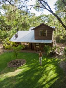 デンマークにあるWilliam Bay Cottagesの家の前の芝生に立つ女