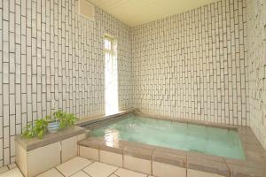 eine Whirlpool-Badewanne in einem gefliesten Zimmer in der Unterkunft Pension Aroma Herbs Le Lagon in Yamanakako