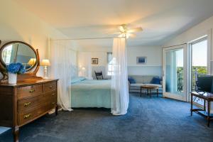 a bedroom with a bed and a dresser and a mirror at Payne's Harbor View Inn in New Shoreham