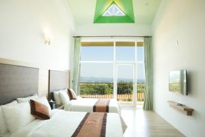 a bedroom with two beds and a large window at Coral B&B in Hengchun