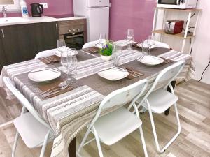 mesa de comedor con sillas blancas y mantel en Casa Ekaterina de Novelda, en Novelda