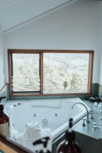 a bath tub in a bathroom with a window at Kangaroo Ridge Retreat in Healesville
