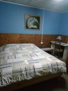 1 dormitorio con 1 cama y una pintura en la pared en Hostal Armando, en Valparaíso